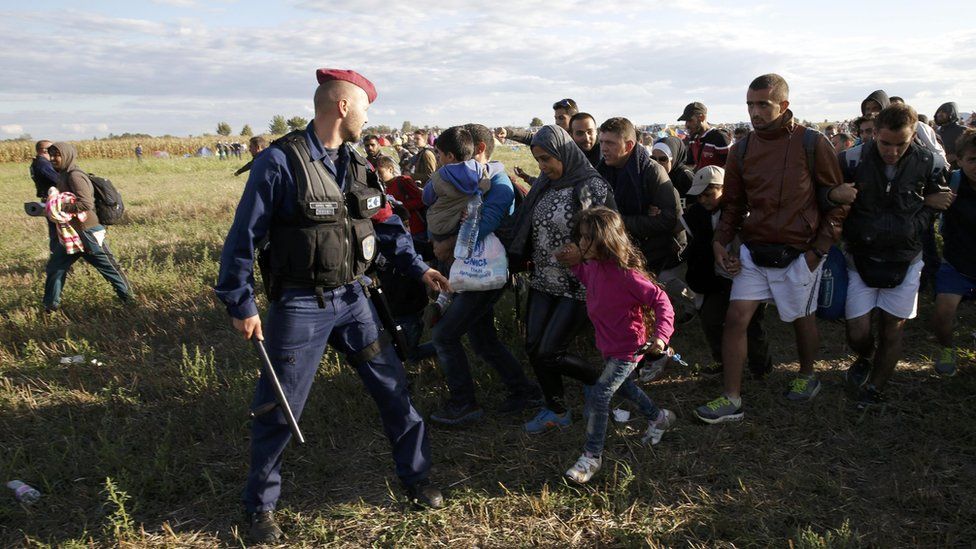Migrants leave a collection point in Roszke, Hungary, 7 Sep