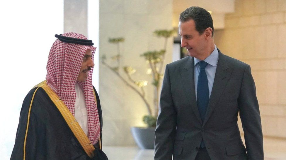Saudi Foreign Minister Prince Faisal bin Farhan (L) walks alongside Syrian President Bashar al-Assad in Damascus, Syria (18 April 2023)