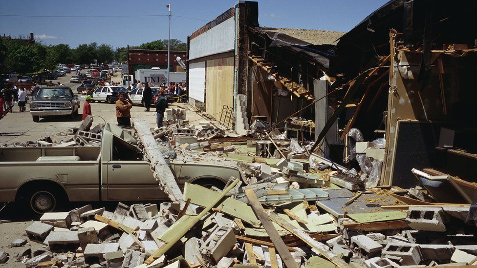 Debris covers a nearby sidewalk in the aftermath of the Oklahoma city bombing.