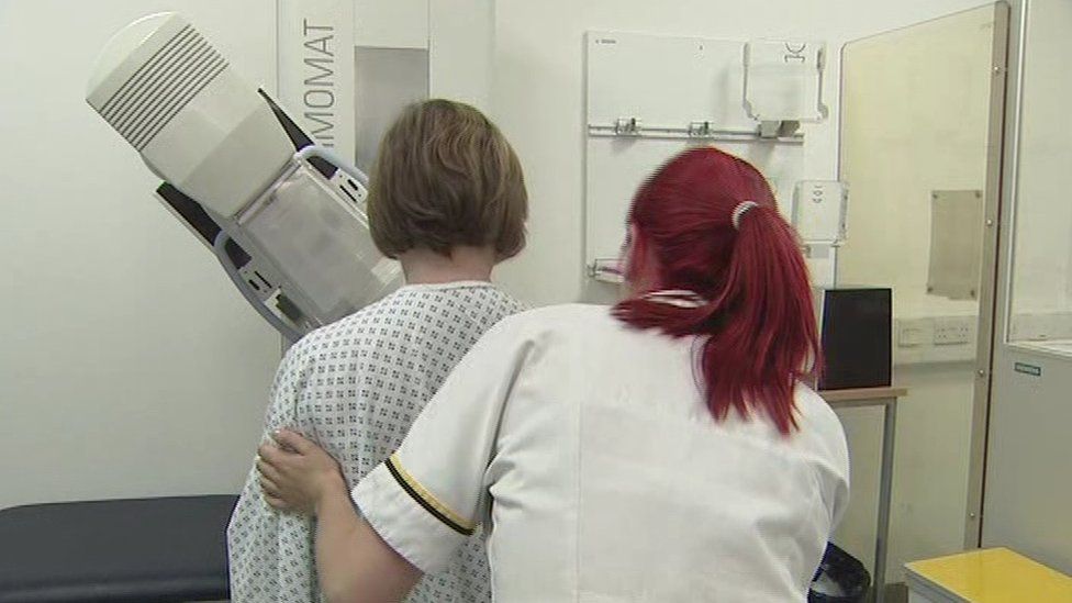 Nurse helping patient during mammogram