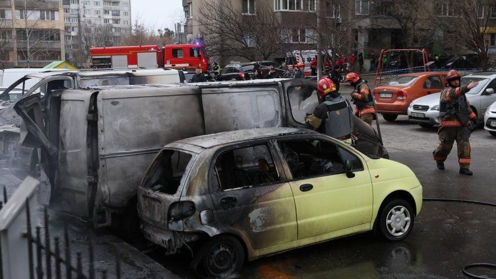 Emergency workers extinguish fire in vehicles at the site of a Russian missile strike, amid Russia's attack on Ukraine, in Kyiv, Ukraine March 9, 2023.