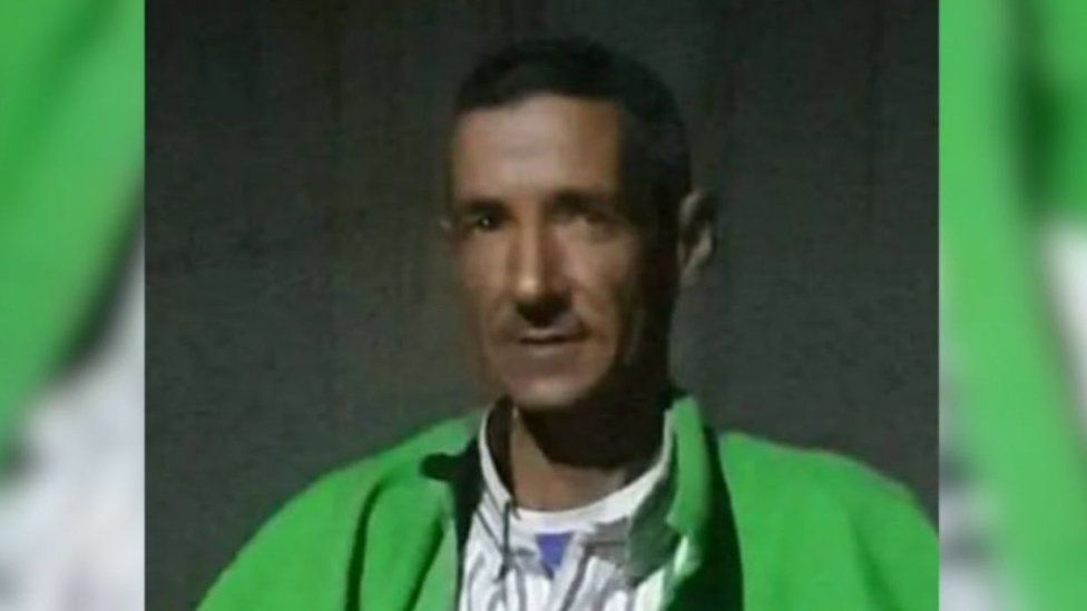 A man wearing a green coat