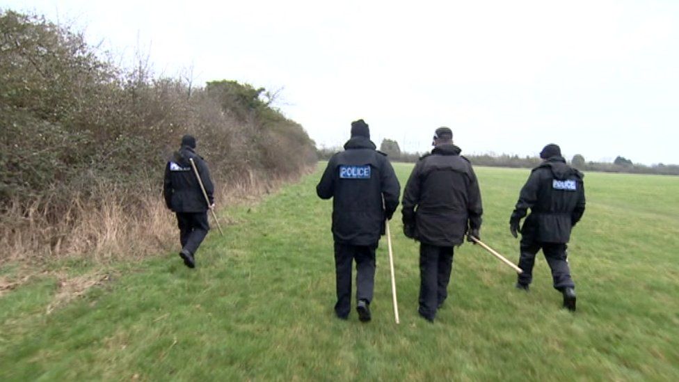 Police officers searching for a missing person