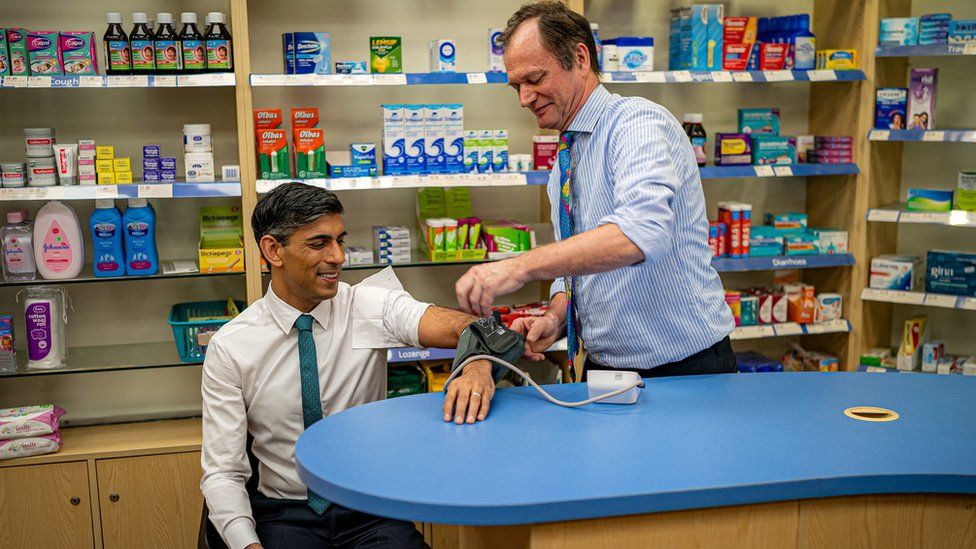 Prime Minister Rishi Sunak has his blood pressure checked by pharmacist Peter Baillie during a visit to a GP surgery and pharmacy in Weston, Southampton, Hampshire