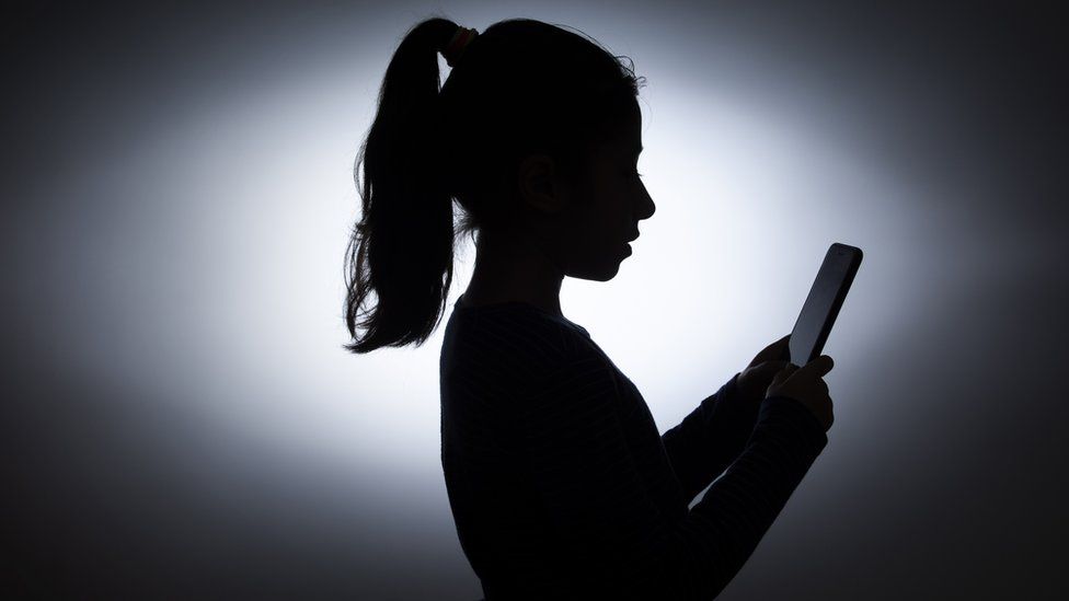 Young woman in silhouette texting
