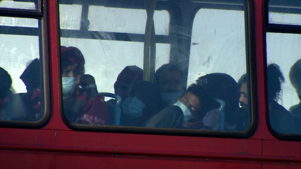 Migrants asleep on board double decker bus at a Kent processing centre