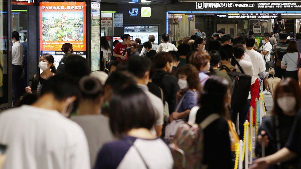 Пассажиры собираются, поскольку движение поездов приостановлено из-за приближения тайфуна Нанмадол Регион Кюсю, станция Хаката в Фукуоке, 18 сентября 2022 г.