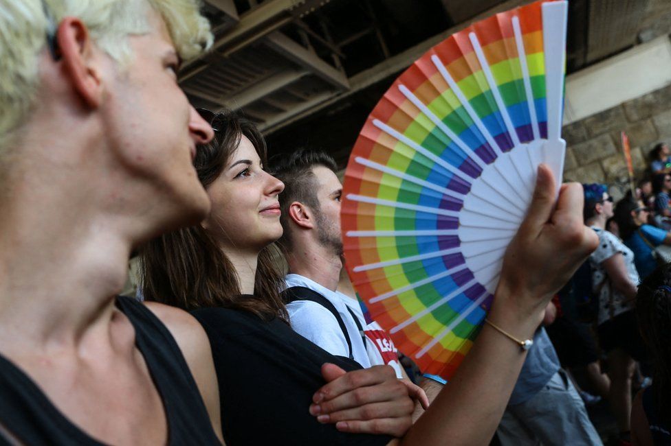 Участница держит веер с радужными цветами во время парада прайдов лесбиянок, геев, бисексуалов и транссексуалов (ЛГБТ) в Будапеште 24 июля 2021 года.