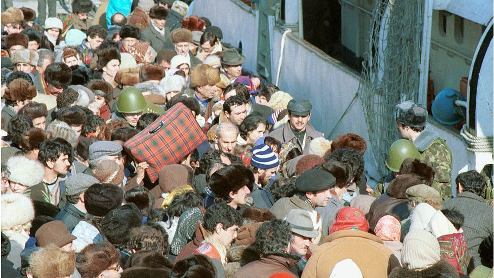 Толпа людей с чемоданами и сумками у парома в бакинской бухте