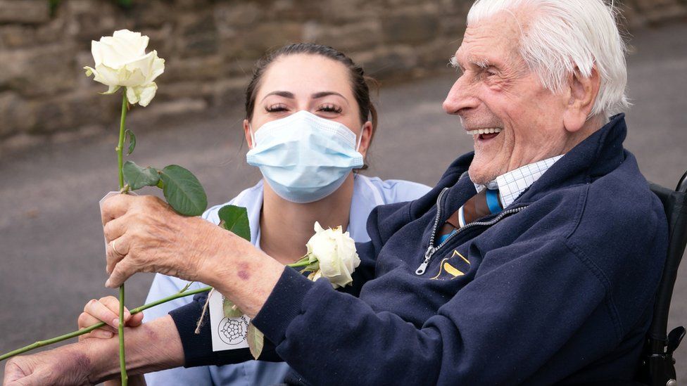 Health Care Assistant Rose Waddington and ninety-eight-year-old resident John Kykot are pictured with "thank you" white roses that were presented to them by the Mayor of West Yorkshire Tracy Brabin at Norwood House Nursing Home in Keighley, as part of the first-ever national Thank You Day