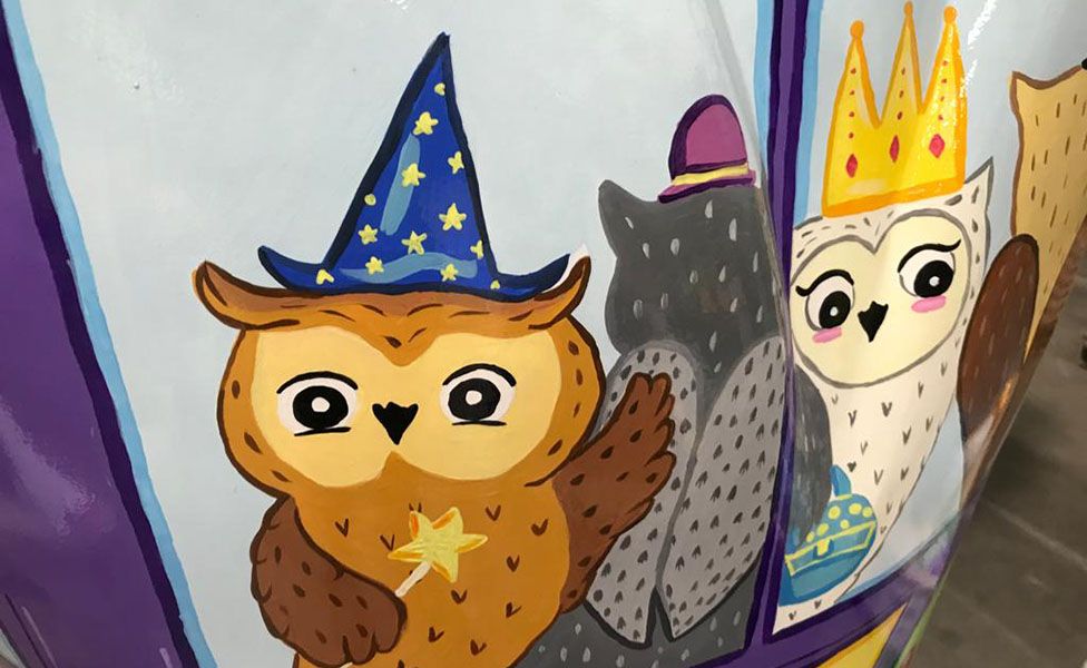 An image of owls wearing hats that has been painted on to one of the sculptures