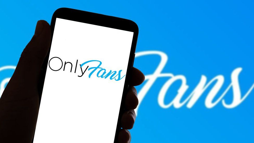 Логотип OnlyFans на смартфоне на синем фоне спереди с логотипом.