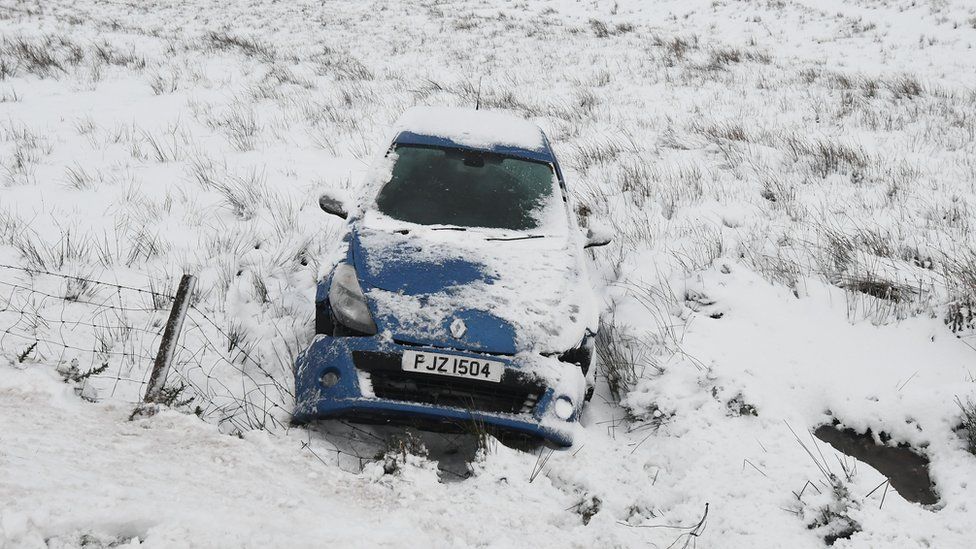 Crashed car in snowy field