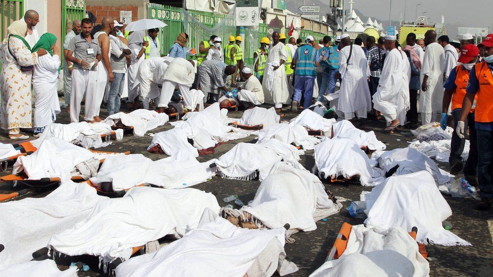 Saudi emergency personnel stand near bodies of Hajj pilgrims at the site where at least 717 were killed and hundreds wounded in a stampede in Mina, near the holy city of Mecca, at the annual hajj in Saudi Arabia on September 24, 2015.