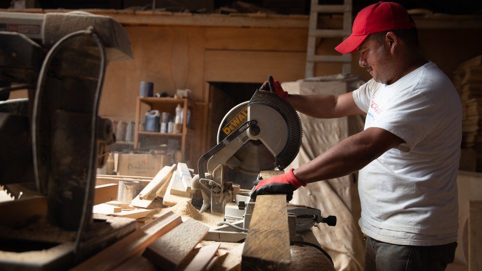 Eduardo Jiménez uses a saw in a carpentry project he created in Cajolá, Guatemala
