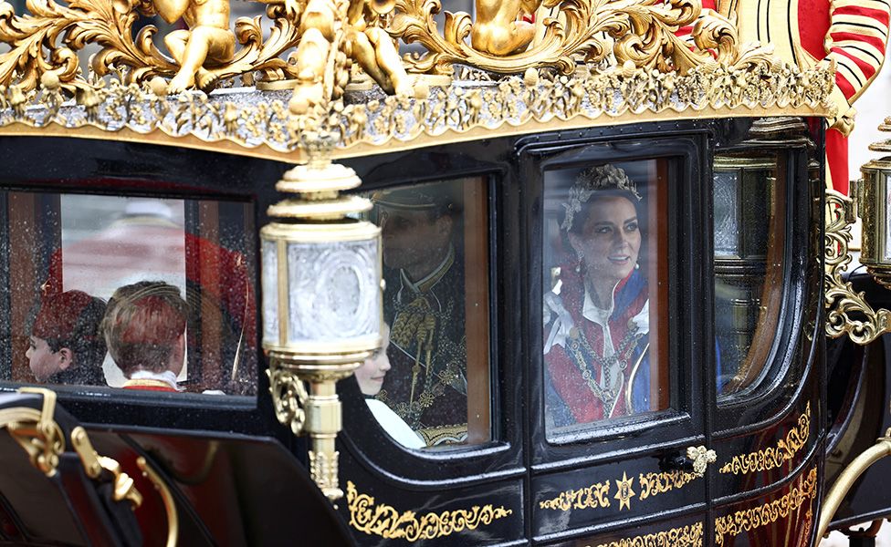 Prince and Princess of Wales and family in a carriage behind the Gold State Coach
