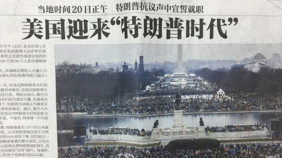A photograph of a Chinese newspaper front page, showing a picture from Donald Trump's inauguration.