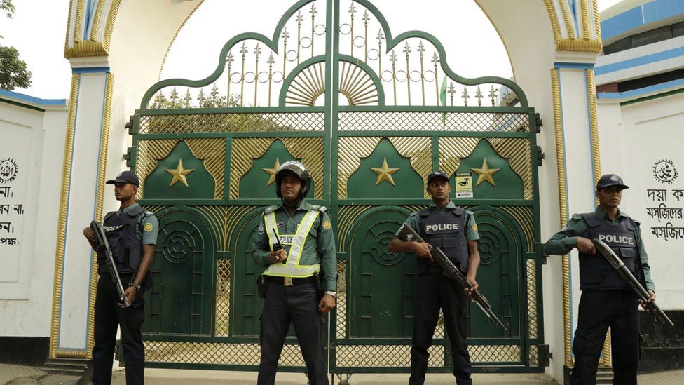 Bangladeshi policemen stand guard in front of a Shia mosque in Dhaka,