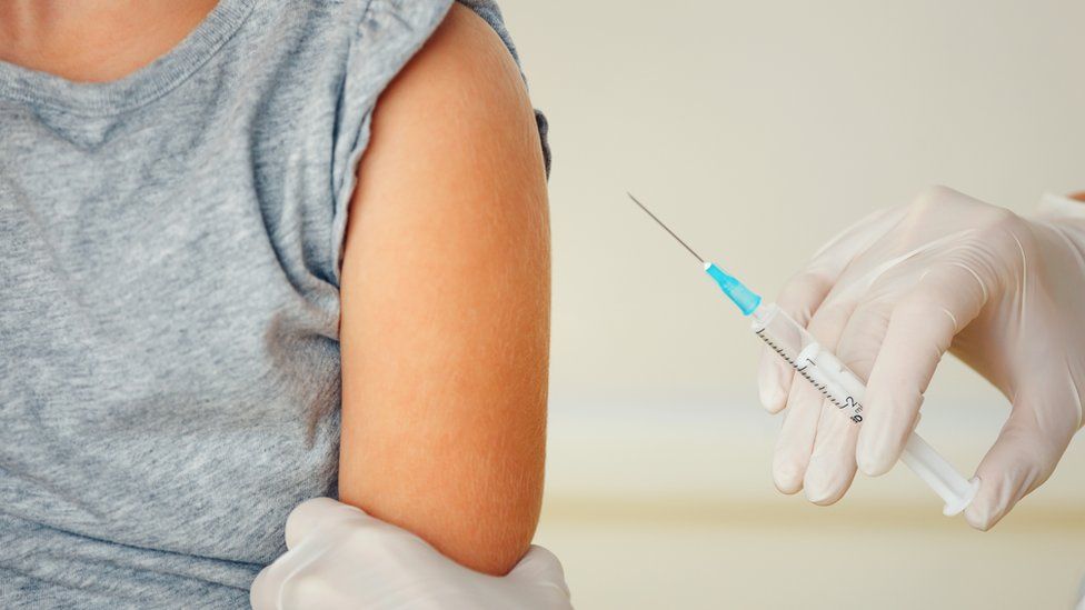 girl wearing grey top getting vaccinated