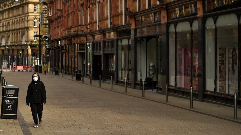Person with mask in empty street in Leeds