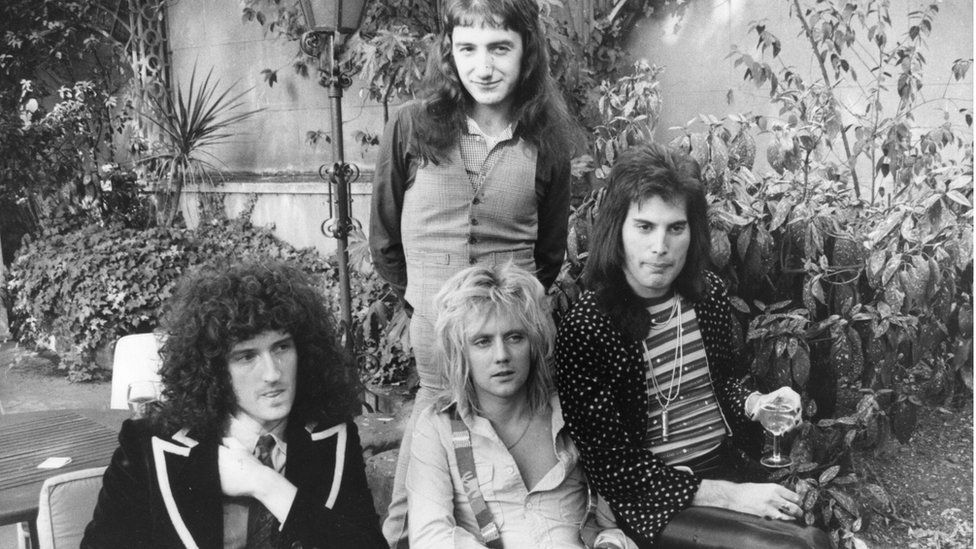 Soldan sağa Brian May, John Deacon (ayakta), Roger Taylor ve Freddie Mercury