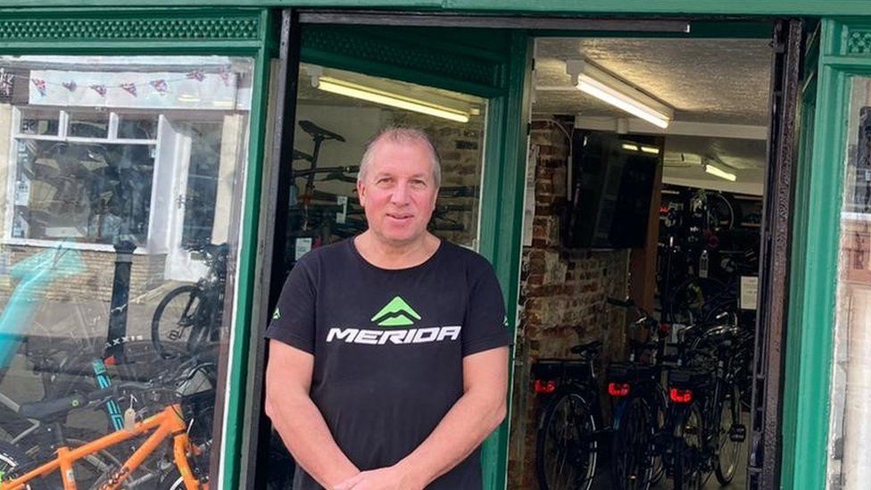 Image of Derek Hailstone stood outside his shop, Mick's Cycles in Bury St Edmunds