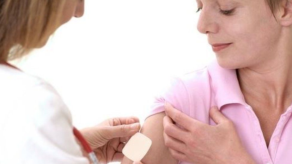 Doctor putting HRT patch on a patient