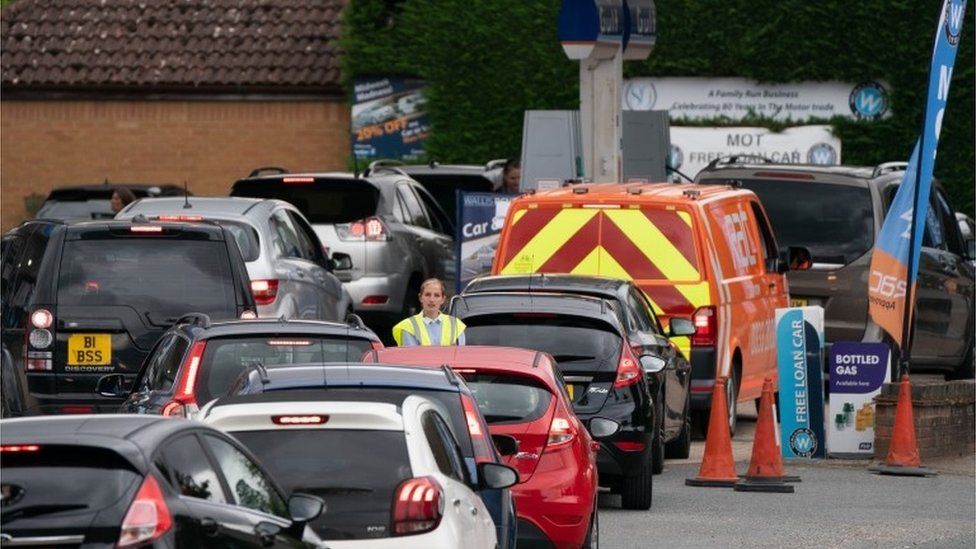 People queue for fuel at a petrol station in Barton, Cambridgeshire