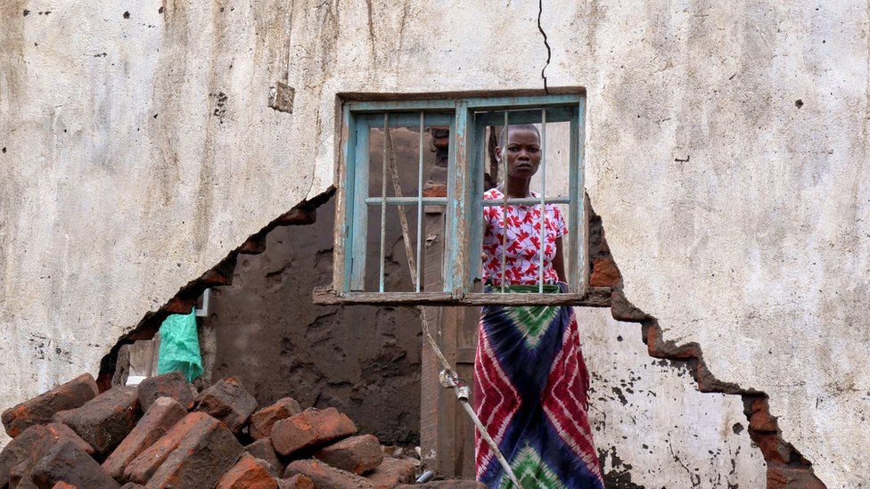 A woman looks on at her house destroyed by Tropical Storm Ana in Malawi