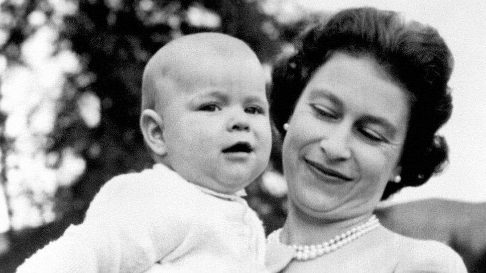 Queen Elizabeth II holding Prince Andrew as a baby