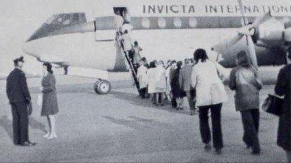 A black and white image of people boarding the flight to Basel in 1973