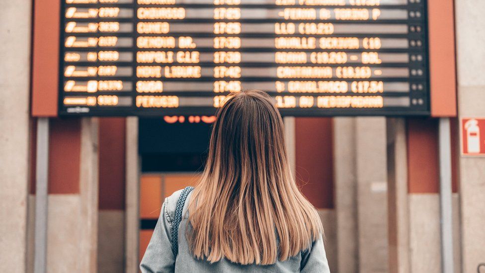 Woman looking at train departure board