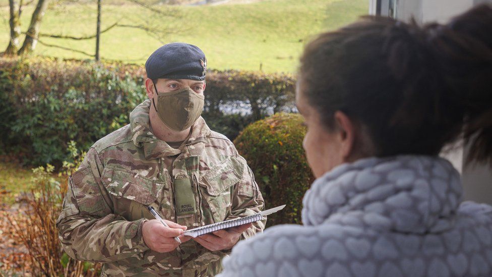 Soldier talks to resident on doorstep