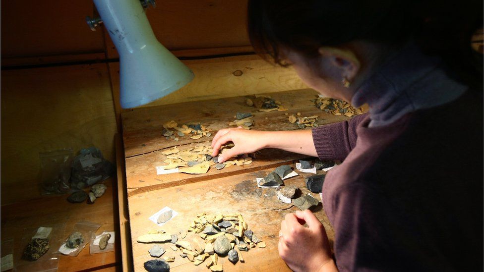 Archaeologist cataloguing finds from the Denisova Cave, Siberia, Russia