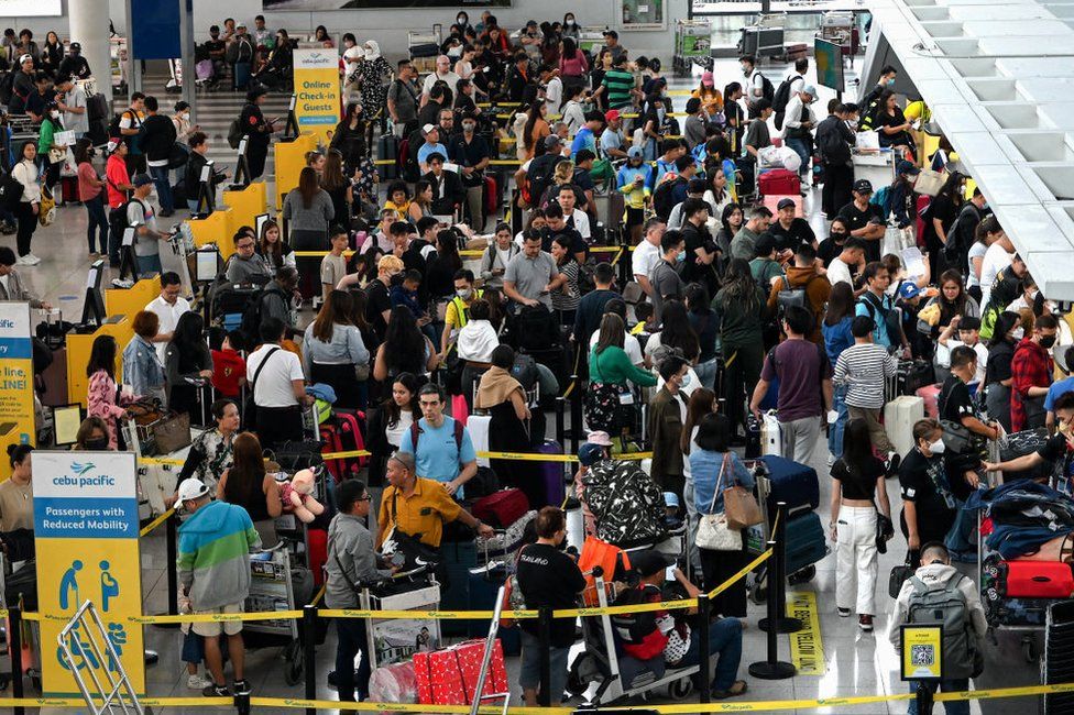 People queue at the check-in counters at Ninoy Aquino International Airport in Pasay, Metro Manila on December 22, 2023, ahead of Christmas celebrations.