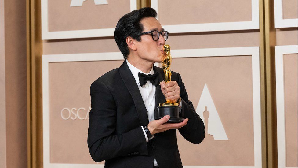 Ke Huy Quan kisses his Oscar award backstage
