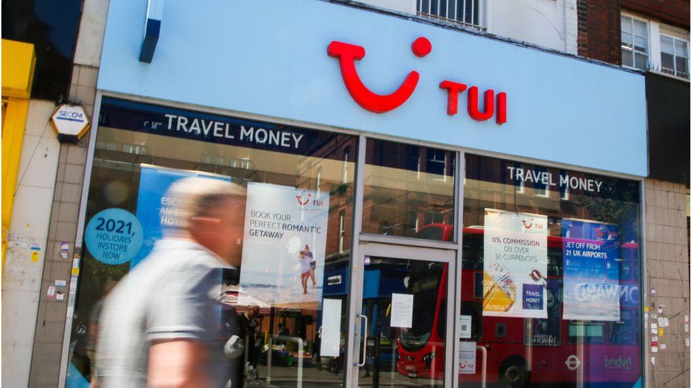 man walks past Tui shop