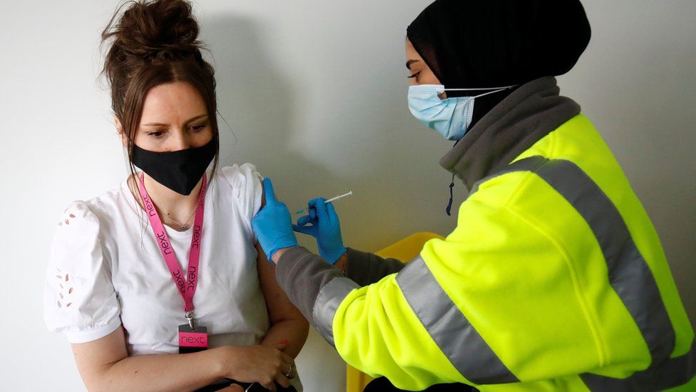 Eve Westwell, 29, receives a dose of Pfizer vaccine against COVID-19 at a vaccination centre in Pharmacy 4 U, amid the outbreak of the coronavirus disease (COVID-19), in Blackburn, Britain,