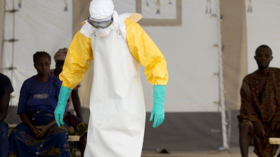 A health worker wearing a protective suit treats Ebola patients in West Africa