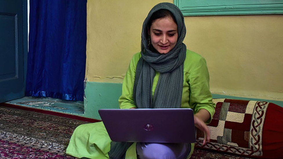 Kashmiri woman photojournalist Sanna Irshad Mattoo looking at her laptop at her residence in Srinagar