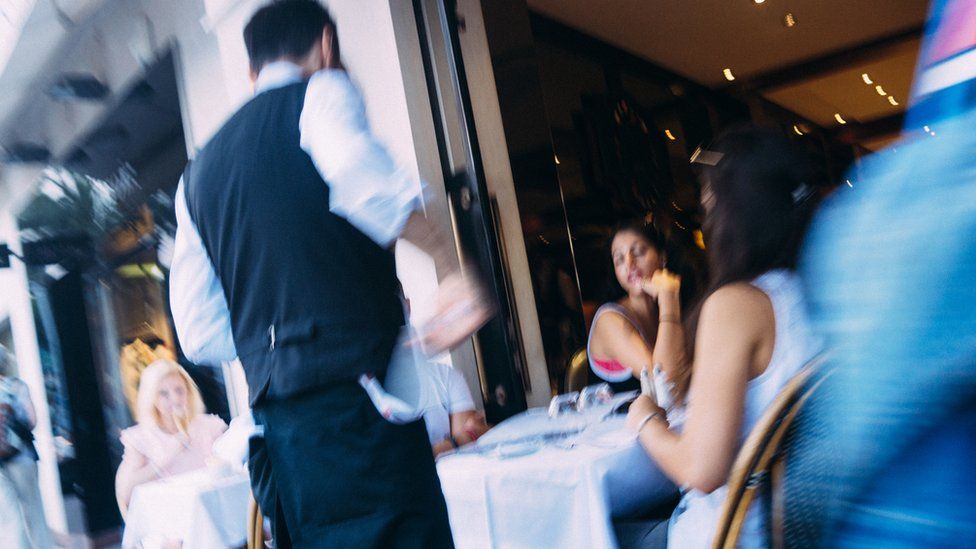 A waiter serves diners