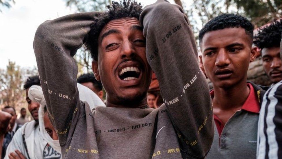A man reacts as people gather around the body of a young man that witnesses say was shot by security forces after breaking curfew, capital of Tigray on February 27, 2021