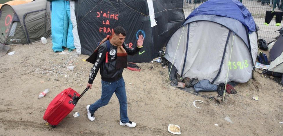 A migrant walks through the Jungle camp in Calais