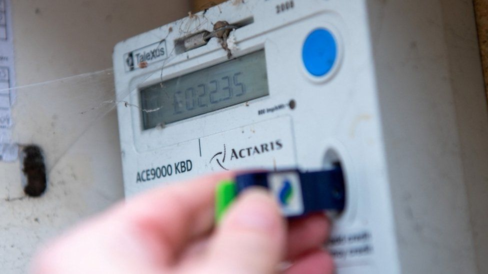 A customer checks the credit on a prepayment electricity meter outside a house in Cardiff