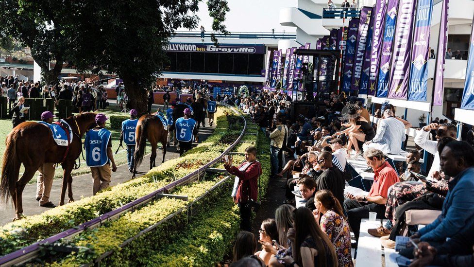 Groomers parade horses at the parade ring during the 2022 edition of the Durban July horse race in Durban, on July 2, 2022.