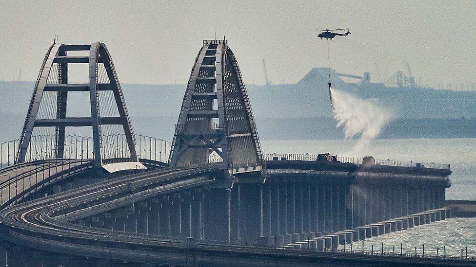 Helicopter pours water on fire on a collapsed part of a bridge that links Crimea with Russia