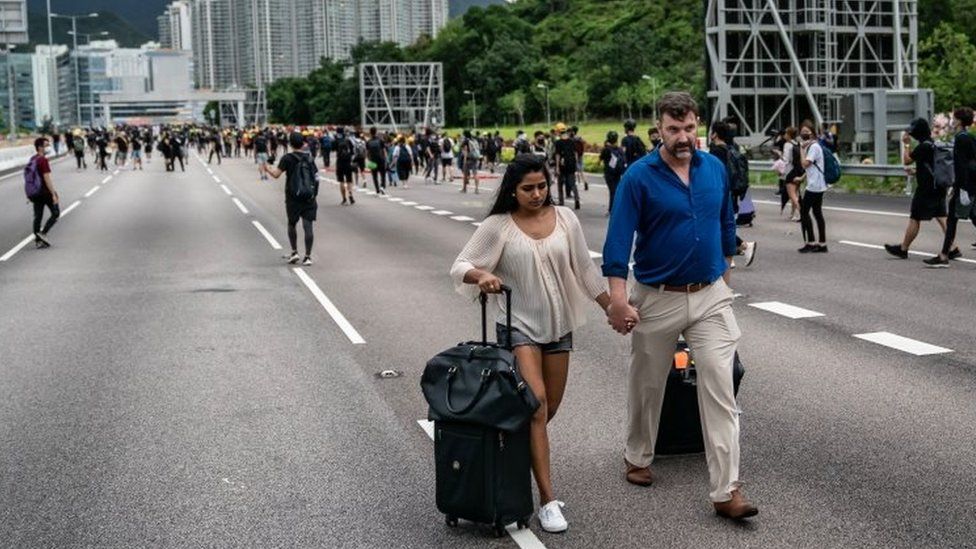 Passengers with their luggage walk to Hong Kong's airport. Photo: 1 September 2019
