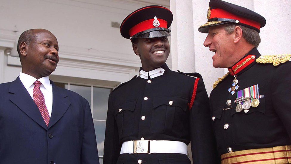 President Yoweri Museveni of Uganda (L) and his son (C) talk with an unidentified officer on the steps of the Royal Military Academy in Sandhurst in London - August 2000