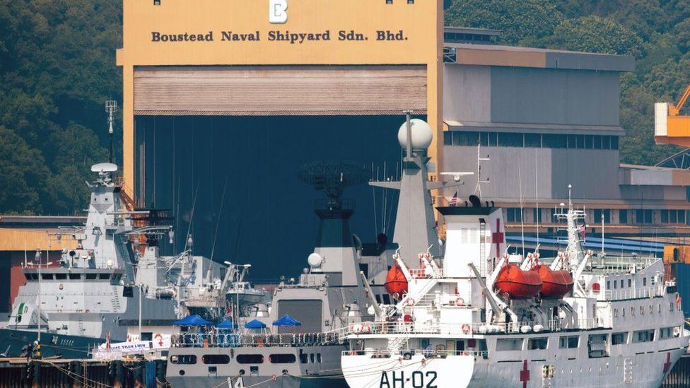 Моряки Королевского военно-морского флота Малайзии (внизу слева) несут вахту с лодки, когда она проходит мимо судов Мьянмы UMS Than Lwin (R) и UMS Sin Phyu Shin (C), которые должны были использоваться для депортации мигрантов из Мьянмы из Малайзии обратно на родину
