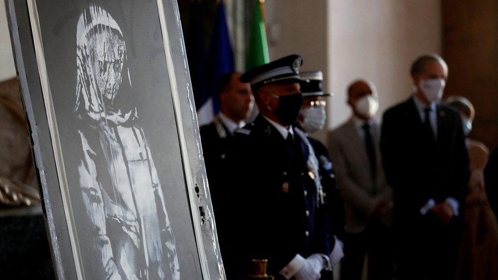 A mural by anonymous British street artist Banksy stolen from the Bataclan theatre in Paris and found in a farmhouse in central Italy is seen during the ceremony to return to France at the French embassy in Rome, Italy. July 14, 2020